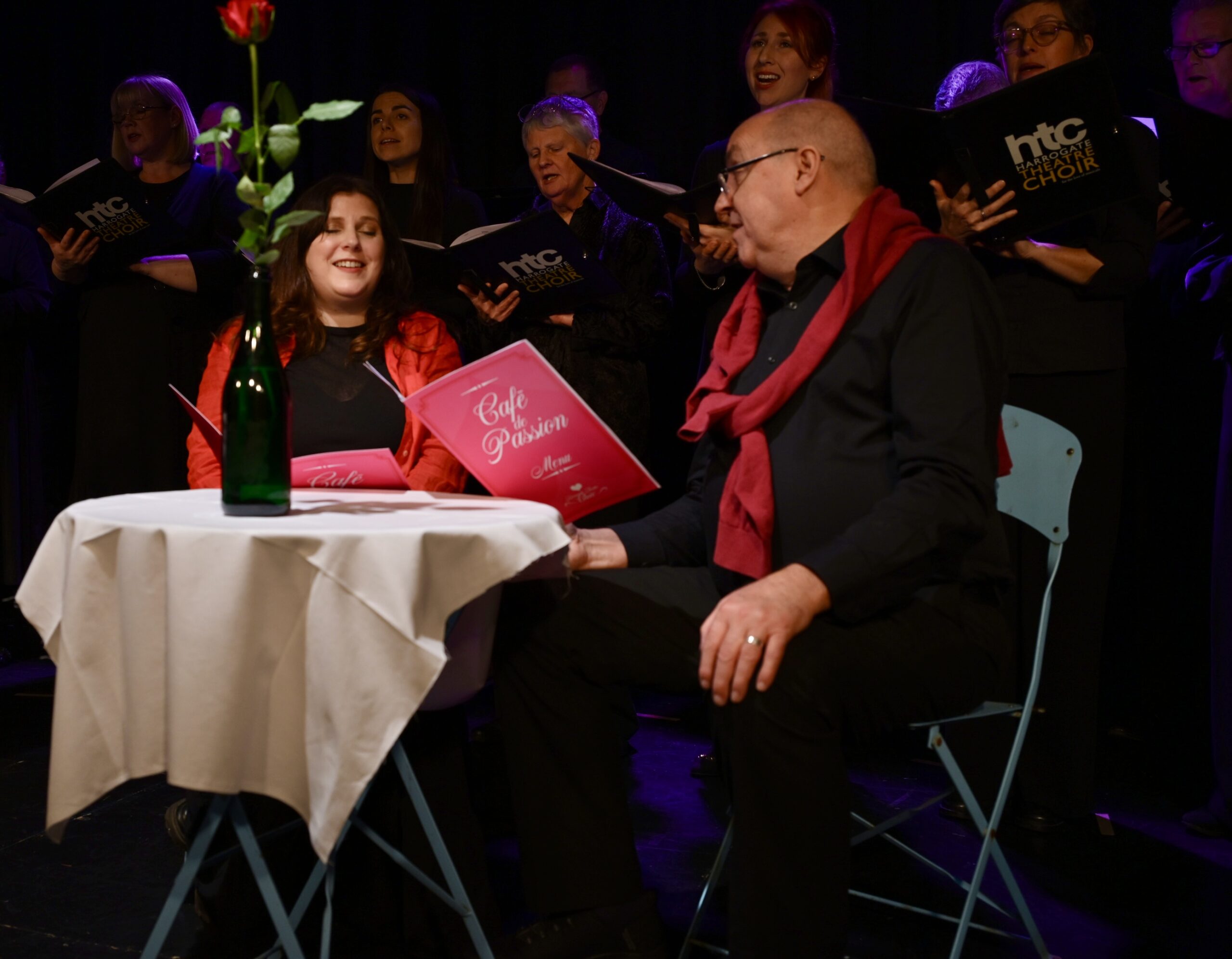 Two people sitting at a dinner table in a romantic setting